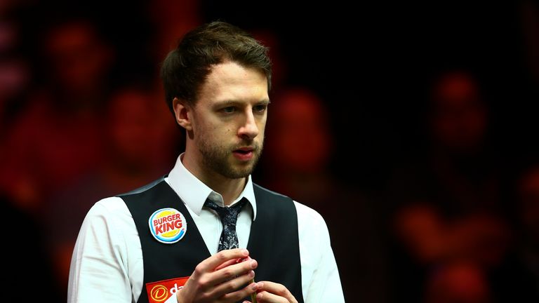 Judd Trump of England chalks his cue in his first round match against Stephen Maguire in Masters