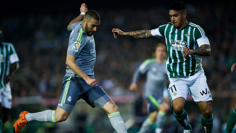 Karim Benzema (left) of Real Madrid competes for the ball with Juan Manuel Vargas of Real Betis 