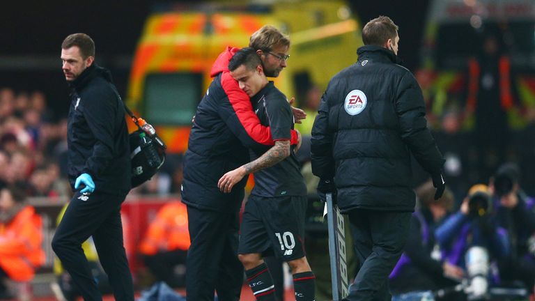 The injured Philippe Coutinho of Liverpool is hugged by Jurgen Klopp as leaves the pitch v Stoke, Capital One Cup semi-final first leg