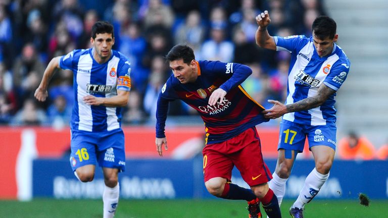 Lionel Messi of FC Barcelona competes for the ball with Hernan Perez (R) and Javi Lopez of RCD Espanyol