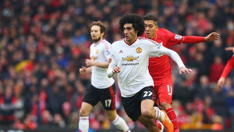 Marouane Fellaini of Manchester United goes past Roberto Firmino of Liverpool