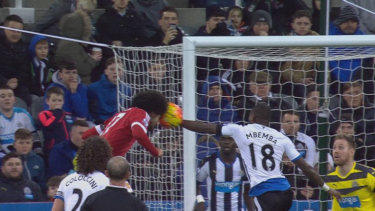 Marouane Fellaini's header is blocked by Chancel Mbemba with his arm