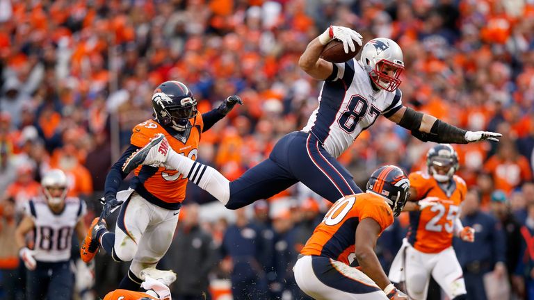 Rob Gronkowski #87 of the New England Patriots is tackled by  Josh Bush #20,  Shiloh Keo #33 and  Danny Trevathan #59 of the Denver Broncos