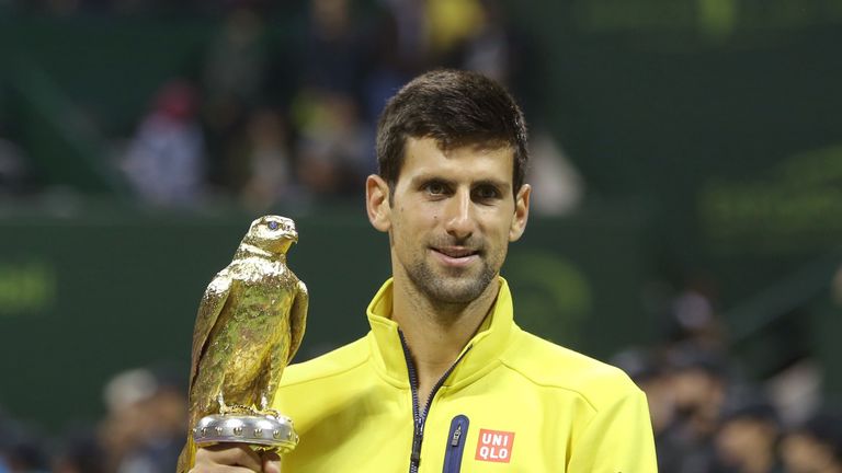 Novak Djokovic celebrates with the winning trophy after beating Rafael Nadal of Spain in the final of the Qatar Open