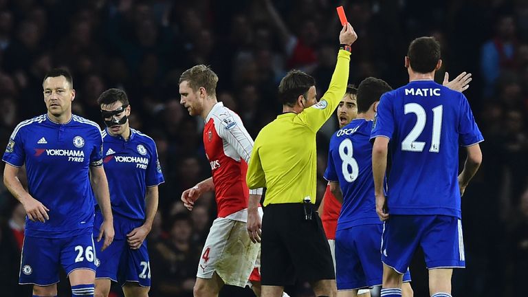 Mark Clattenburg shows a red card to Arsenal defender Per Mertesacker