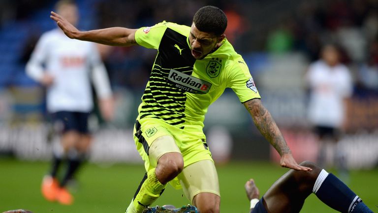 Nahki Wells of Huddersfield Town is tackled by Bolton's Prince-Desir Gouano