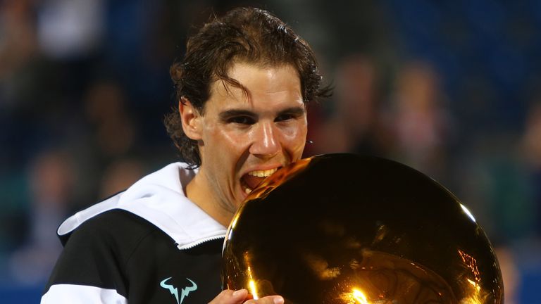 Spanish player Rafael Nadal poses with his trophy after beating Canadian player Milos Raonic in the final match of the Mubadala World Tennis Championship