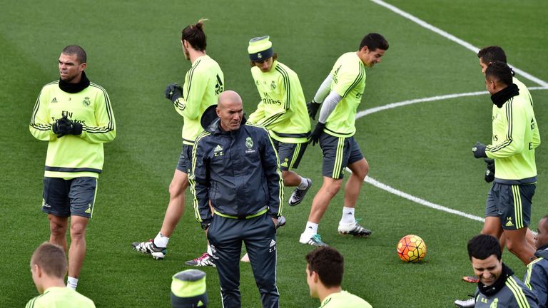 Real Madrid's new French coach Zinedine Zidane (C) looks at his players during a training session at the Valdebebas training ground in Madrid