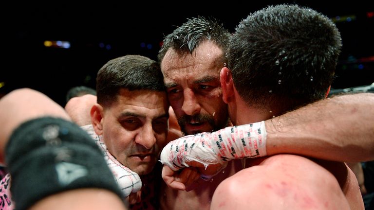 Robert Guerrero (middle) hugs Danny Garcia (R) and trainer Angel Garcia after the WBC championship welterweight bout 