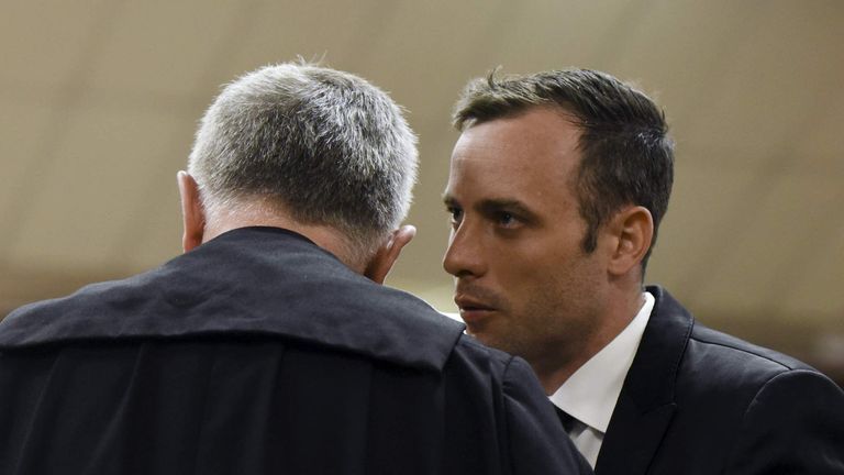 Oscar Pistorius speaks to his lawyer Barry Roux