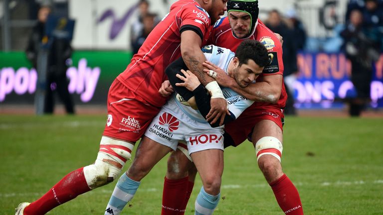 Scarlets pair Maselino Paulino (L) and George Earle (R) tackle Racing 92 full-back Brice Dulin