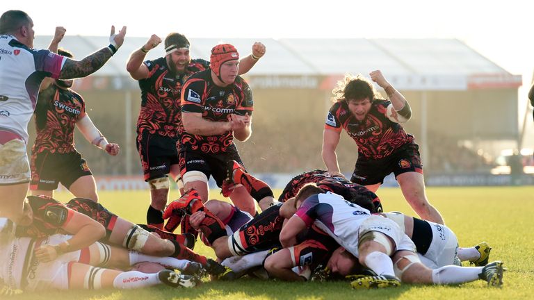 Exeter Chiefs players celebrate their first try scored by Kai Horstmann (floor) against Ospreys