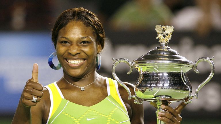 Serena Williams of the US gives a thumbs up as she holds the winner's trophy following her victory in the women's singles final match