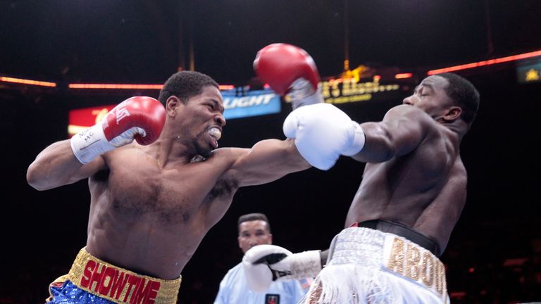 Shawn Porter (L) punches at Adrien Broner