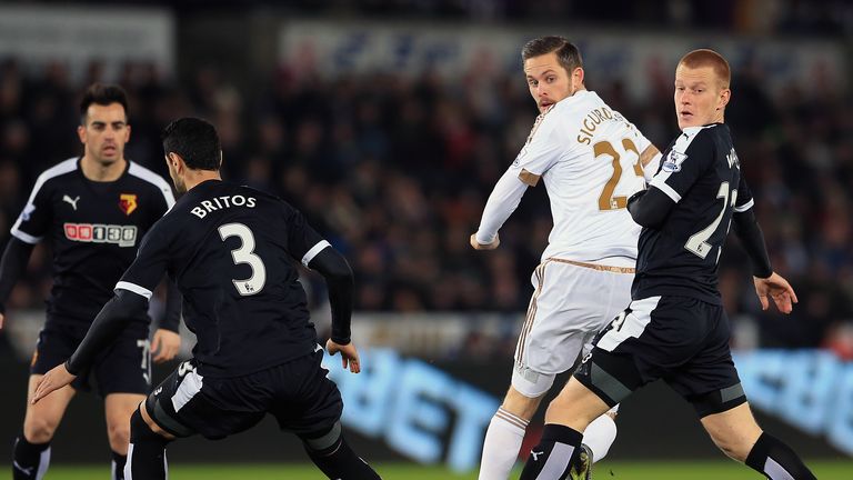 Swansea City's Gylfi Sigurdsson (centre) and Watford's Ben Watson (right) and Miguel Britos battle for the ball during the Barclays Premier League match at
