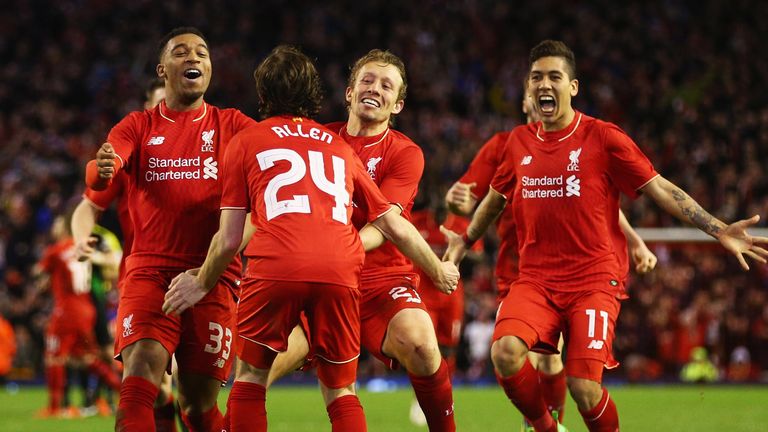 Joe Allen of Liverpool is congratulated after scoring the winning penalty against Stoke