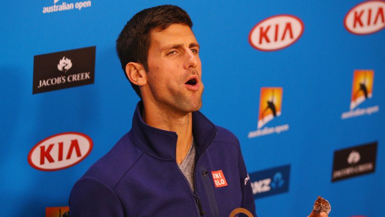 Novak Djokovic of Serbia reacts when eating one of his chocalates that he gave away to media during a practice session