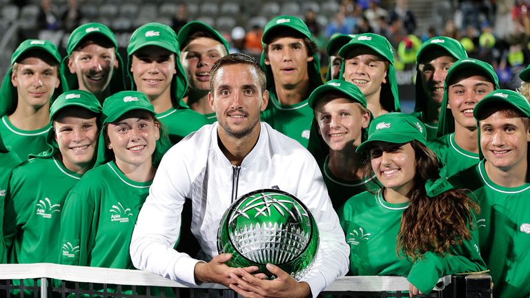 Viktor Troicki of Serbia poses with ballboys as he celebrates and holds the winners trophy in Sydney