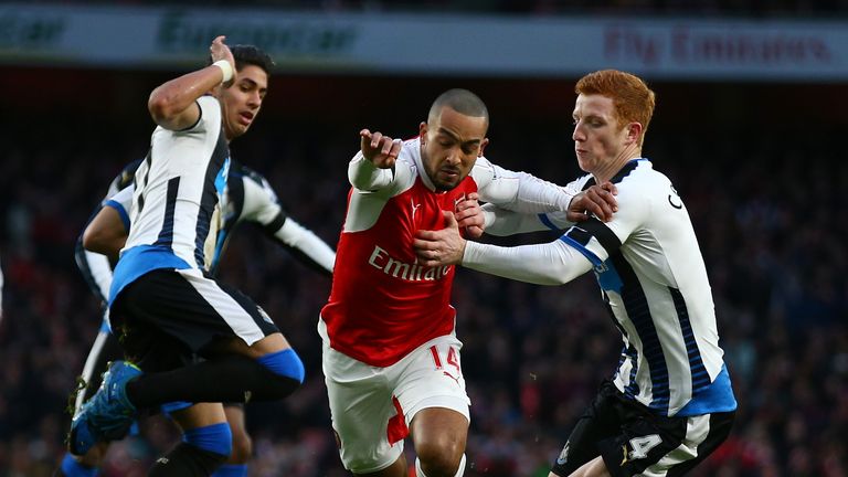 Theo Walcott of Arsenal and Jack Colback of Newcastle United compete for the ball 