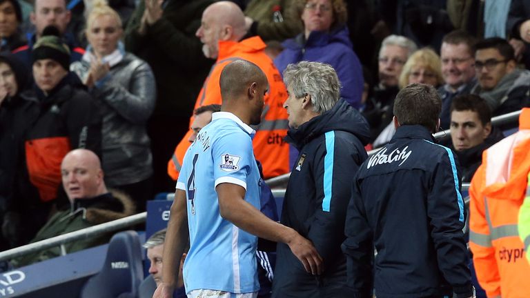 Manchester City's Vincent Kompany walks off injured past Manchester City manager Manuel Pellegrini