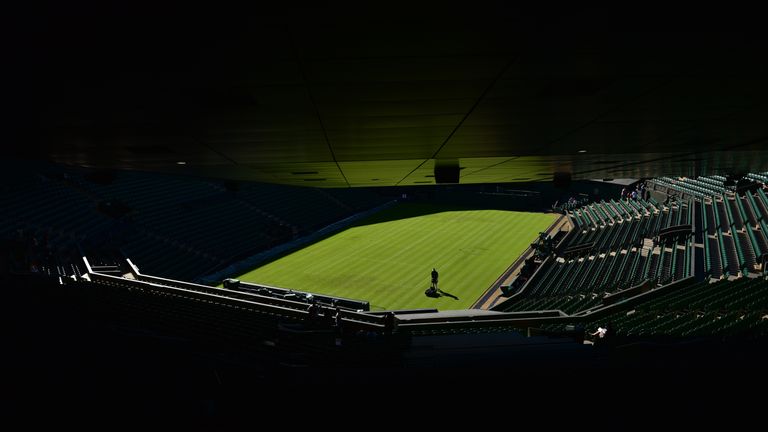 A groundsman prepares the grass on Centre Court