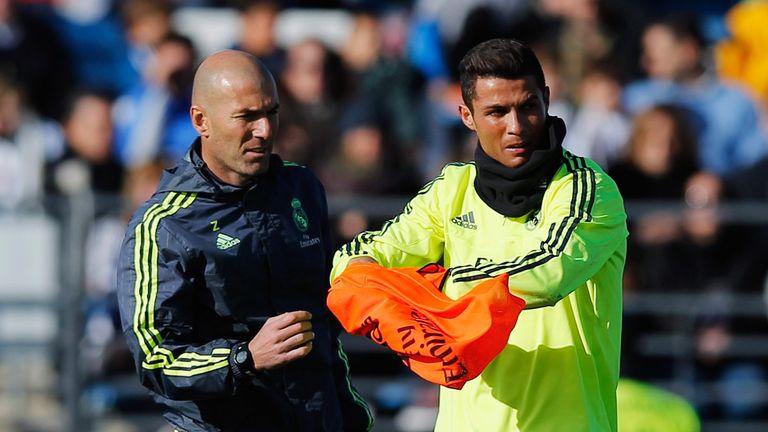 Newly appointed manager of Real Madrid Zinedine Zidane hands a bib to Cristiano Ronaldo during a Real Madrid training session 