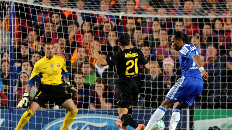 Didier Drogba of Chelsea shoots past Adriano and goalkeeper Victor Valdes of Barcelona to score the opening goal in the 2012 Champions League semi final