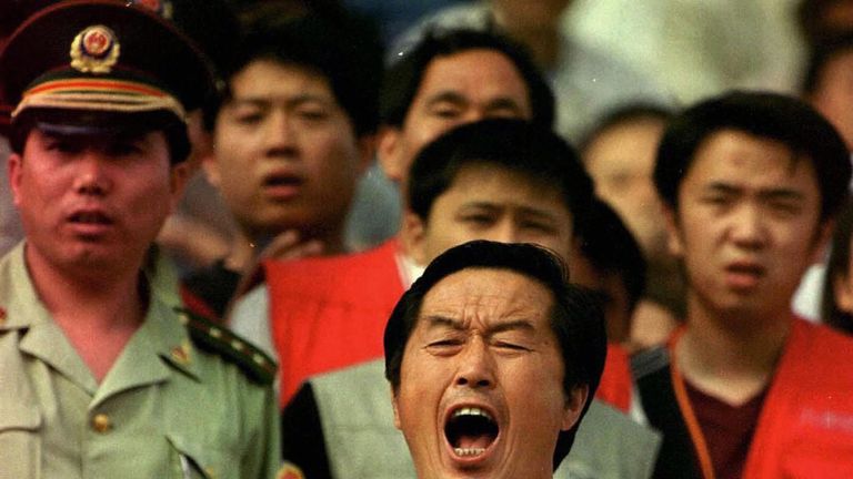 Chinese coach Ma Junren yells to his athletes as he checks their times at the Olympic track and field trials in Jinzhou, northeast China June 7 2000. AFP P