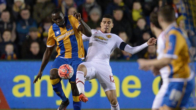 Shrewsbury Town's English defender Jermaine Grandison vies with Manchester United's English defender Chris Smalling