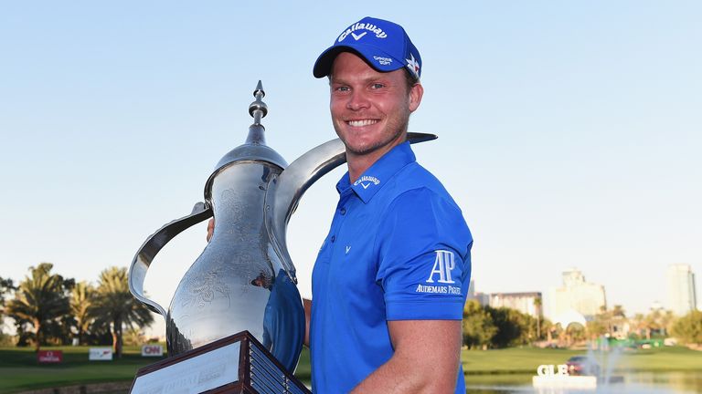 Danny Willett of England poses with the trophy after his victory in the Omega Dubai Desert Classic