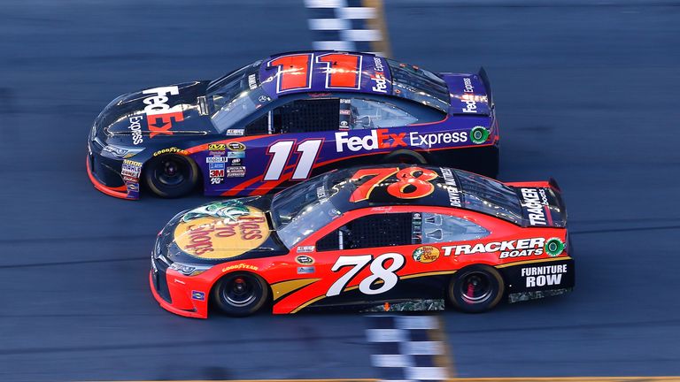 Denny Hamlin, driver of the #11 FedEx Express Toyota, takes the checkered flag ahead of Martin Truex Jr., driver of the #7