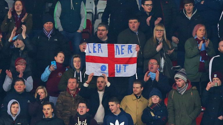 Aston Villa supporter holds a banner protesting against owner Randy Lerner after the Premier League match at Stoke