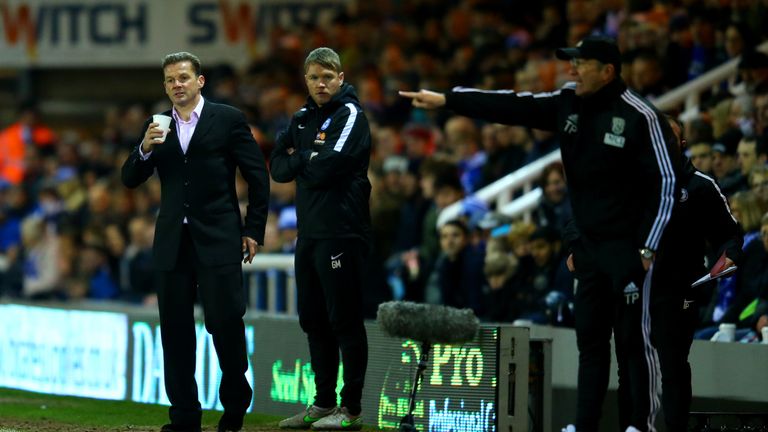 PETERBOROUGH, ENGLAND - FEBRUARY 10:  Graham Westley, manager of Peterborough holds a drink as he watches the action while Tony Pulis, manager of West Brom