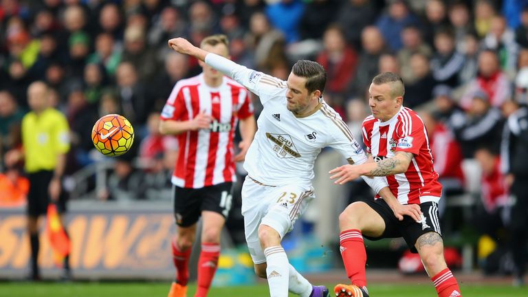 Gylfi Sigurdsson of Swansea City controls the ball under pressure of Jordy Clasie of Southampton 