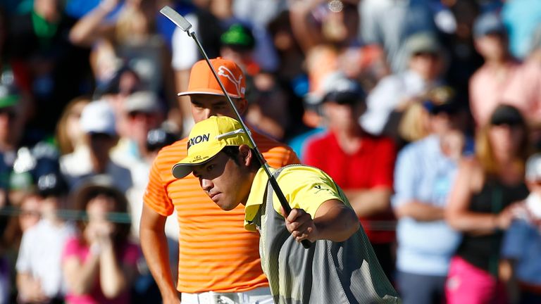 Hideki Matsuyama of Japan celebrates a birdie putt on the 18th hole as Rickie Fowler looks on 