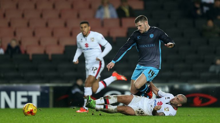 Gary Hooper of Sheffield Wednesday is tackled by Samir Carruthers of Milton Keynes Dons during the Sky Bet Champions