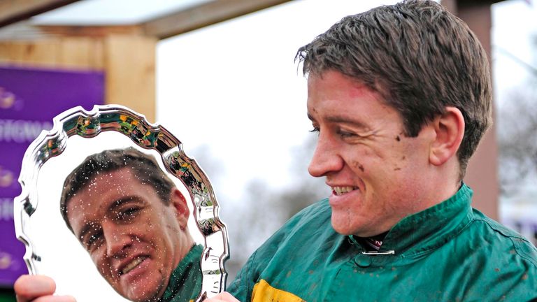 Jockey Barry Geraghty celebrates with the trophy after winning the Deloitte Novice Hurdle onboard Bleu Et Rouge during the Irish Gold Cup at Leopardstown R
