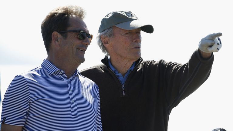musician Huey Lewis talks to actor Clint Eastwood on the 18th tee box during the 3M Celebrity Challenge prior to the