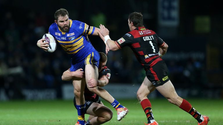 Leeds Rhinos' Adam Cuthbertson is tackled by Warrington Wolves' Jack Hughes and Kurt Gidley
