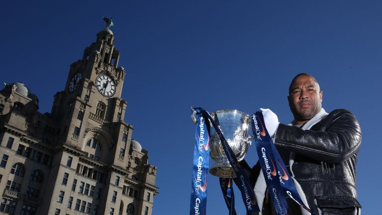 John Barnes holds up the Capital One Cup trophy in front of the Liver Building