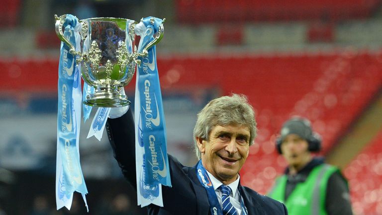 Man City manager Manuel Pellegrini holds up the Capital One Cup