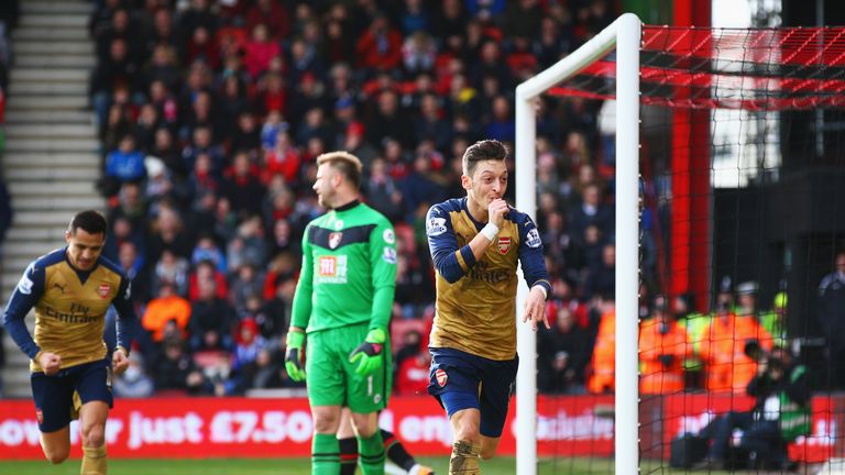 Goalkeeper Artur Boruc of Bournemouth looks dejected as Mesut Ozil of Arsenal celebrates as he scores their first goal