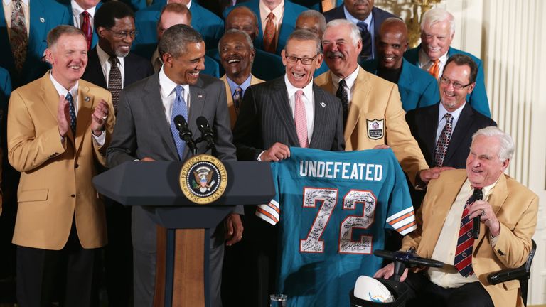 WASHINGTON, DC - AUGUST 20:  First row, U.S. President Barack Obama (2nd L) is presented with a jersey by current team owner Stephen Ross (3rd L) as member