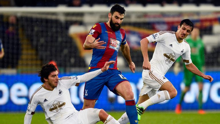 SWANSEA, WALES - FEBRUARY 06: Mile Jedinak of Crystal Palace is tackled by Alberto Paloschi of Swansea City during the Barclays Premier League match betwee
