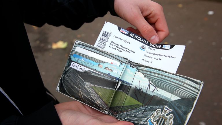 A Newcastle United fans shows his match ticket as he removes it from his NUFC wallet 