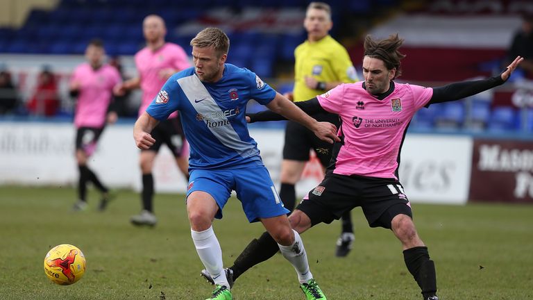 Nicky Featherstone of Hartlepool United looks to move away from the challenge of Ricky Holmes of Northampton Town