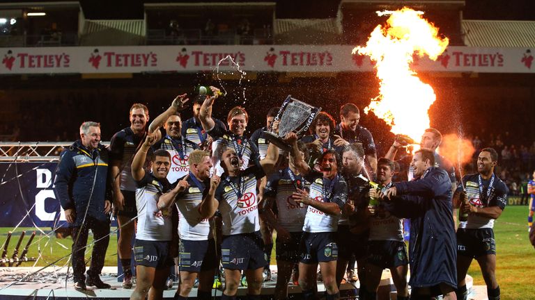 Johnathan Thurston and Matthew Scott of North Queensland Cowboys lift the World Club Series trophy after victory over Leeds Rhinos at Headingley