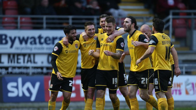 Northampton players celebrate one of James Collins' goals as they stayed top of League Two by thrashing Leyton Orient