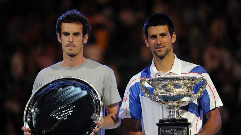 Novak Djokovic of Serbia (R) holds the winner's trophy after beating Andy Murray of Britain (L) who poses with the runner's-up shield in 2011