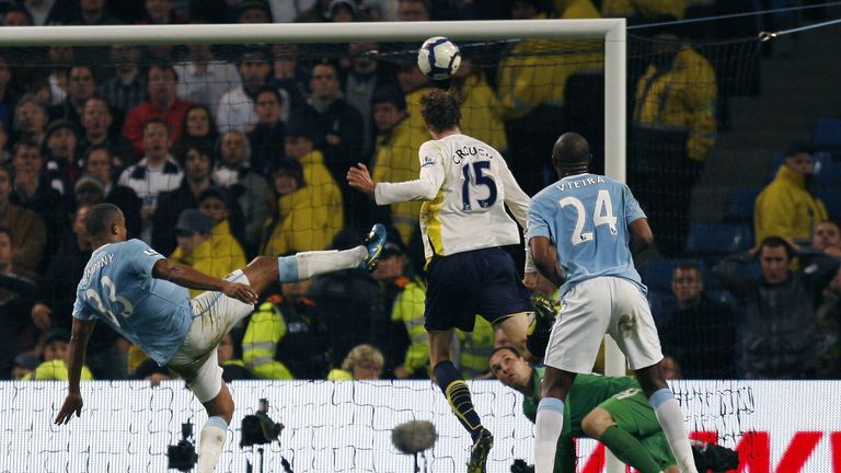 Tottenham Hotspurs Peter Crouch (C) scores his goal against Manchester City challenged by Manchester City's Belgium player Vincent Kompany (L) during a Pre
